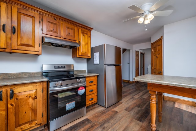 kitchen featuring dark wood-style floors, stainless steel appliances, brown cabinetry, ceiling fan, and under cabinet range hood