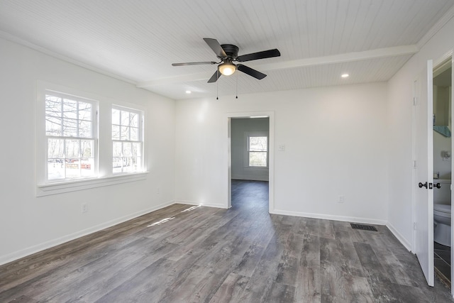 spare room featuring dark wood-style floors, visible vents, baseboards, and beam ceiling