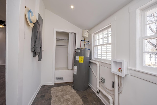 utility room featuring electric water heater and visible vents