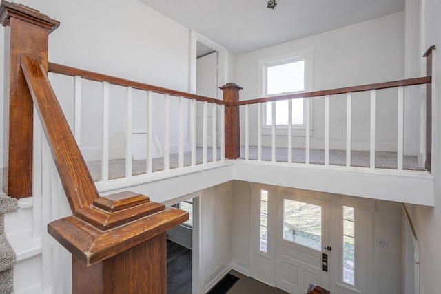 foyer featuring visible vents, stairway, and a high ceiling