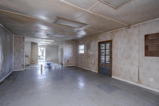 spare room featuring wallpapered walls, baseboards, a wealth of natural light, and tile patterned floors