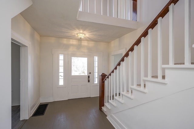 entrance foyer featuring stairs, wood finished floors, visible vents, and baseboards