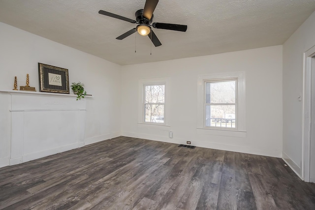 unfurnished room with dark wood-style flooring, visible vents, a textured ceiling, and baseboards