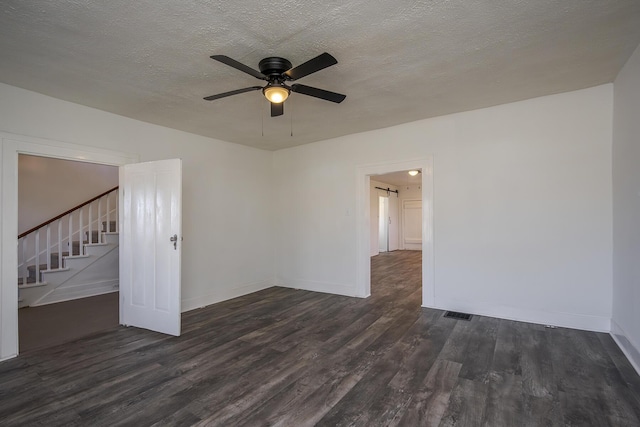 spare room with ceiling fan, a textured ceiling, wood finished floors, baseboards, and stairs