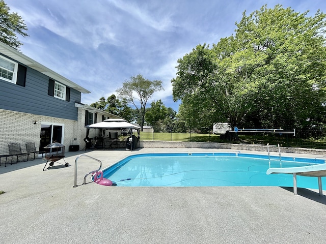 view of swimming pool with a water slide, fence, a gazebo, a fenced in pool, and a patio area