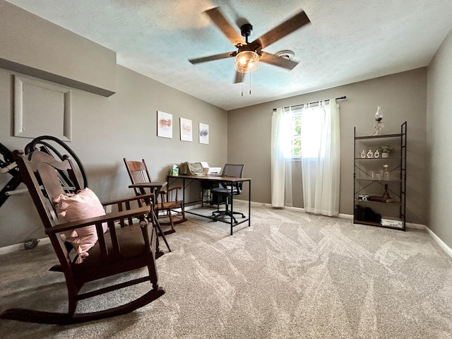 home office with a ceiling fan, light colored carpet, a textured ceiling, and baseboards