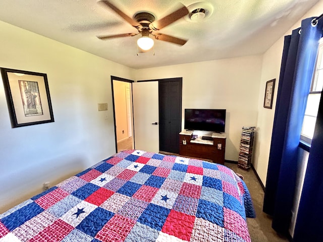 bedroom featuring carpet floors, ceiling fan, a closet, and a textured ceiling