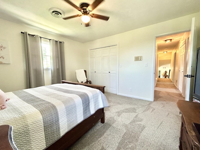 bedroom featuring light colored carpet, a ceiling fan, baseboards, visible vents, and a closet