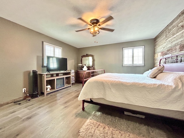 bedroom with ceiling fan, a textured ceiling, and light wood-style flooring