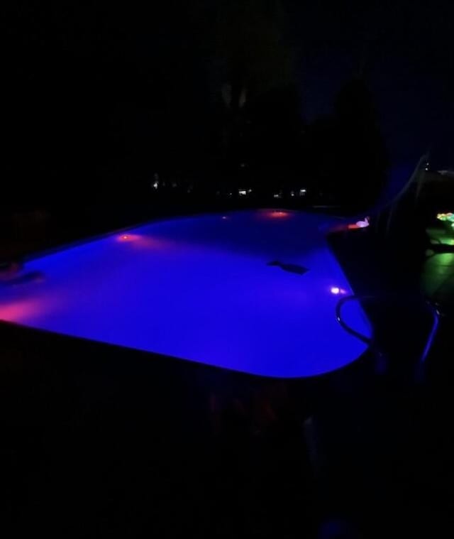 view of pool at twilight