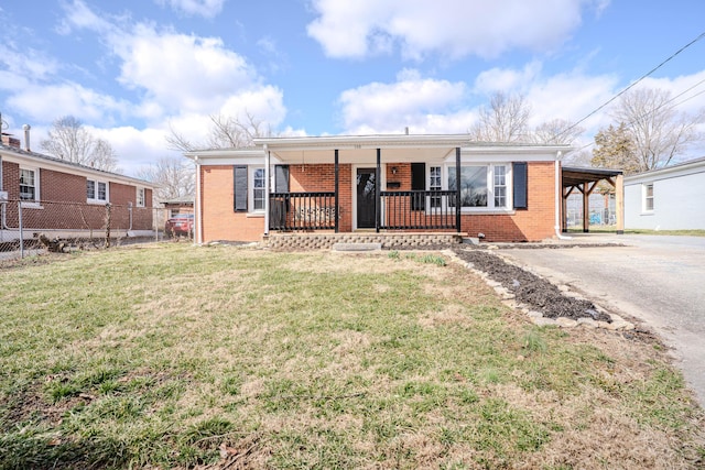 view of front of home featuring brick siding, a porch, a front yard, a carport, and driveway