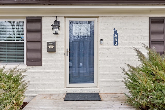 doorway to property featuring brick siding