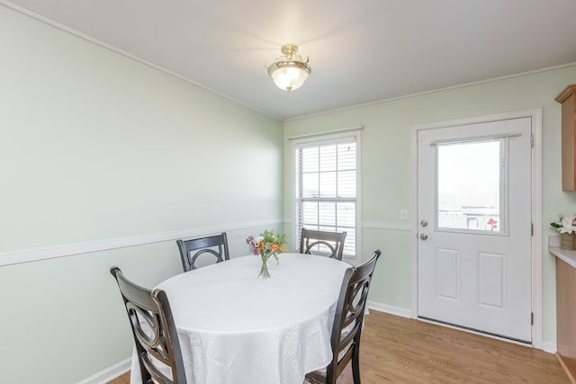 dining area featuring light wood-style flooring and baseboards