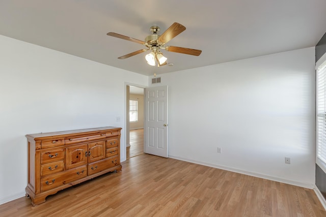 bedroom featuring a ceiling fan, light wood-type flooring, visible vents, and baseboards