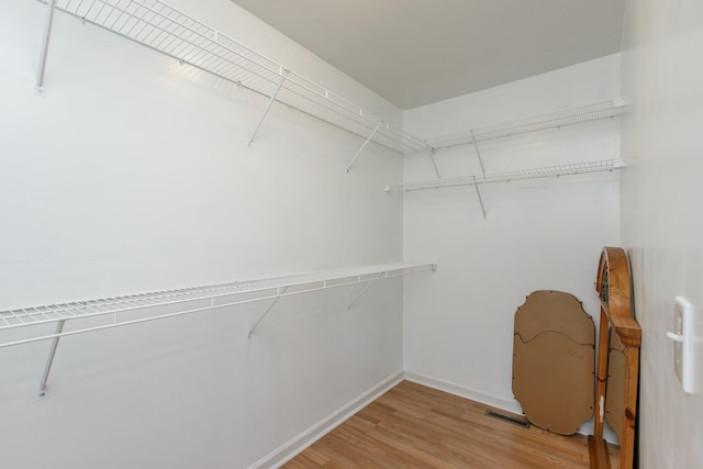 walk in closet featuring light wood-type flooring and visible vents