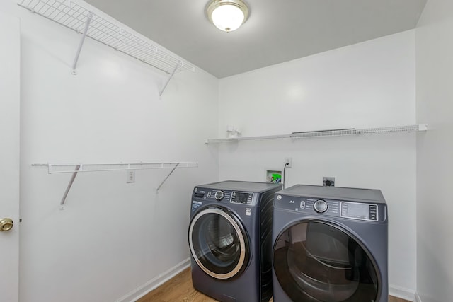 washroom with laundry area, baseboards, wood finished floors, and independent washer and dryer