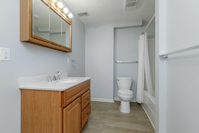 bathroom with toilet, wood finished floors, visible vents, vanity, and baseboards