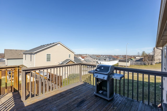 deck featuring an outbuilding, a yard, a grill, and a residential view