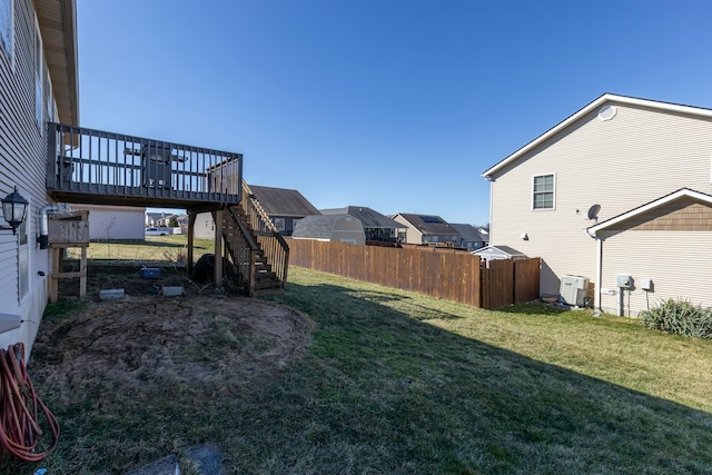 view of yard featuring stairs, a deck, central AC unit, and fence