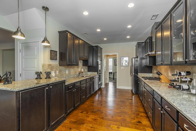 kitchen featuring glass insert cabinets, a peninsula, appliances with stainless steel finishes, and dark wood-style floors