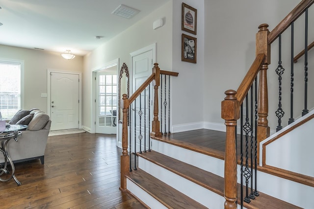 entryway featuring stairs, visible vents, dark wood-style flooring, and baseboards