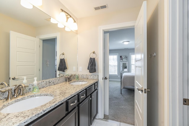 full bath featuring ensuite bath, double vanity, visible vents, and a sink