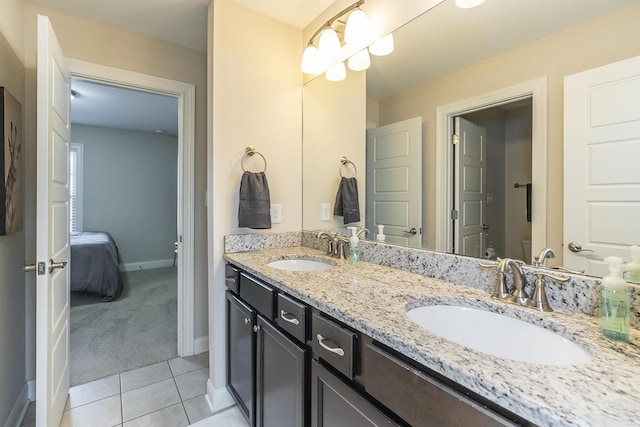 full bath with a sink, baseboards, double vanity, and tile patterned flooring