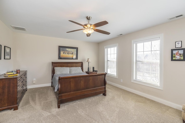 bedroom featuring visible vents, light colored carpet, and baseboards