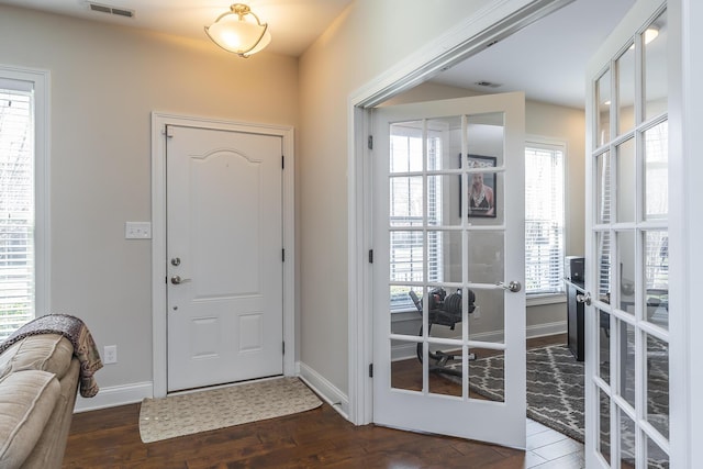 foyer featuring wood finished floors, french doors, visible vents, and baseboards