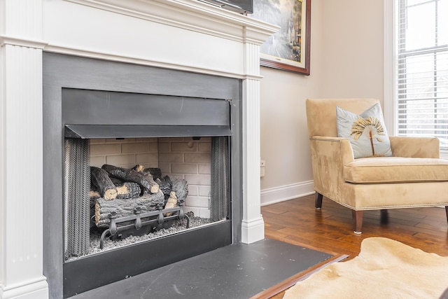 interior details featuring baseboards, wood finished floors, and a fireplace