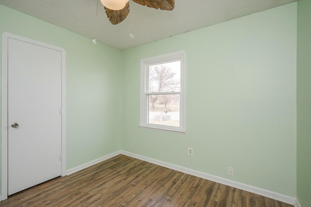 unfurnished room featuring a textured ceiling, ceiling fan, wood finished floors, and baseboards