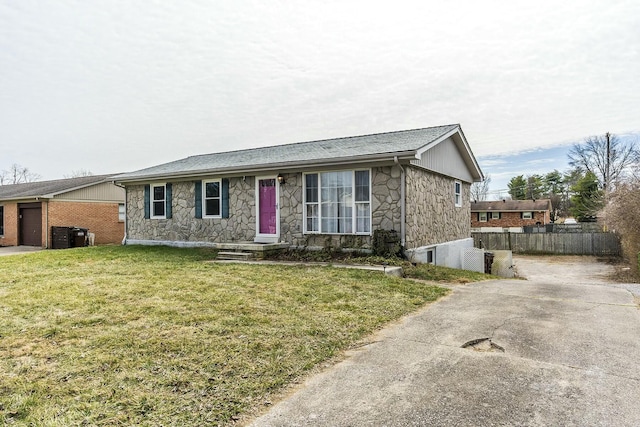 ranch-style house with a garage, stone siding, a front yard, and fence