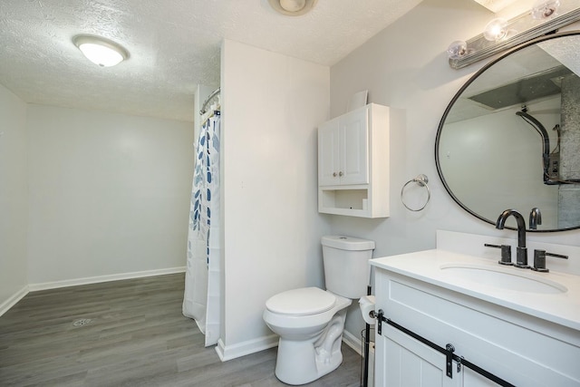 bathroom featuring baseboards, a textured ceiling, toilet, and wood finished floors