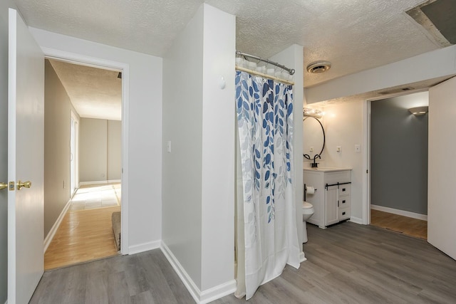 full bathroom featuring visible vents, vanity, baseboards, and wood finished floors