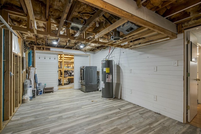 unfinished below grade area featuring washer / clothes dryer, wood finished floors, and electric water heater