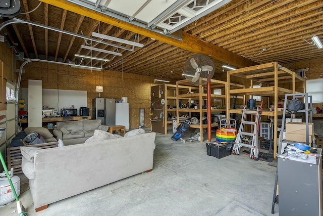 garage featuring fridge and stainless steel refrigerator with ice dispenser