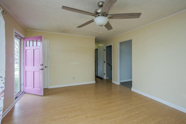 unfurnished room featuring ornamental molding, baseboards, a textured ceiling, and light wood finished floors