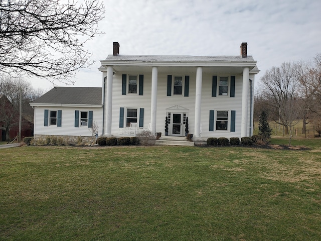 greek revival house with a front yard and a chimney