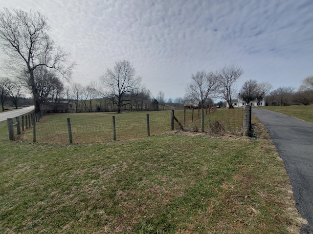 view of yard featuring fence and a rural view