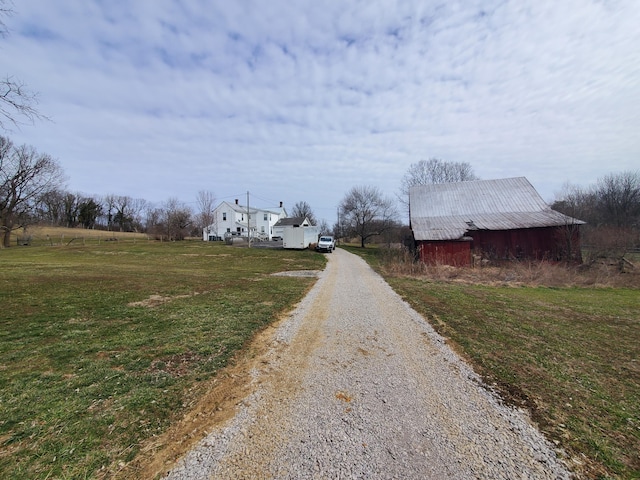 view of street with driveway and a barn