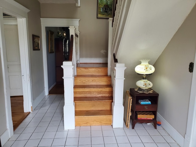 stairs featuring visible vents, baseboards, and tile patterned floors