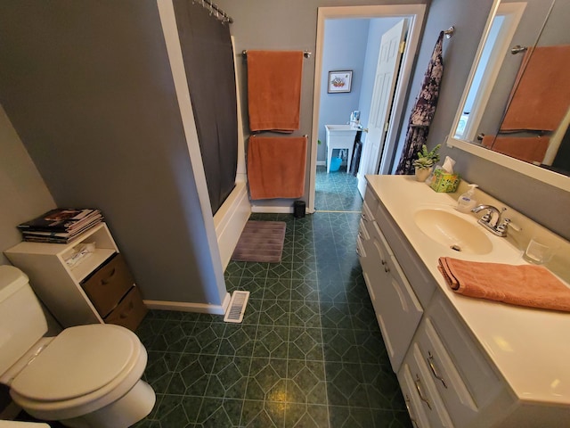 bathroom with toilet, baseboards, walk in shower, and vanity