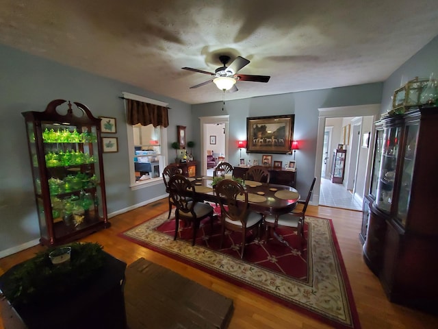 dining room with ceiling fan, baseboards, and wood finished floors