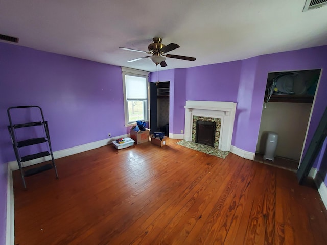 unfurnished living room featuring wood finished floors, visible vents, and baseboards