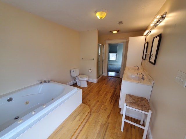 full bath with double vanity, toilet, a stall shower, a sink, and a tub with jets