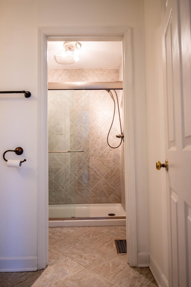 bathroom with a shower stall, visible vents, and baseboards