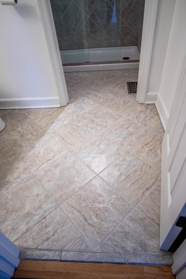 full bath featuring a shower stall, visible vents, and baseboards