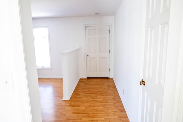 corridor featuring baseboards and light wood-style floors