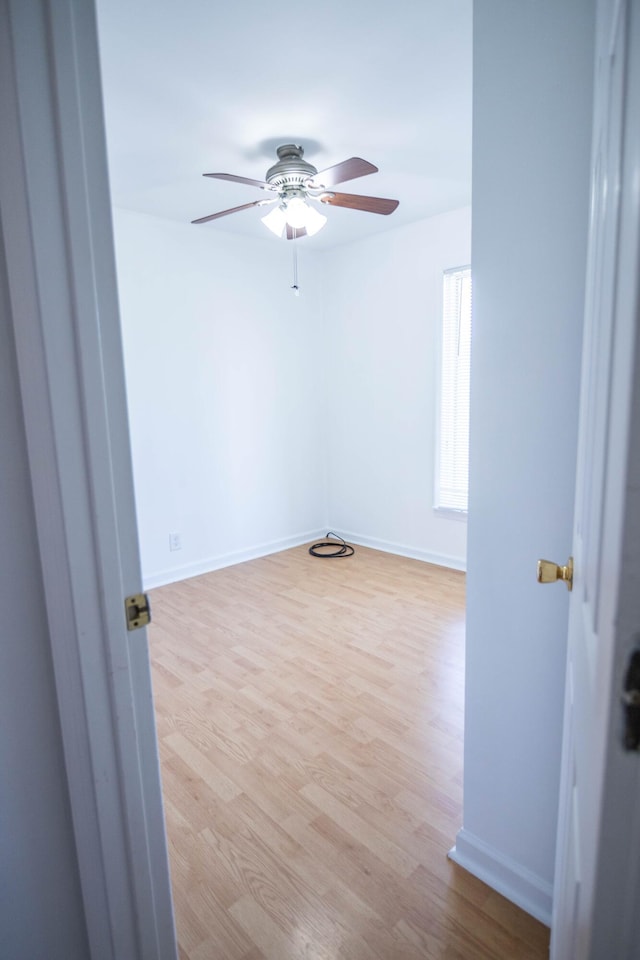 unfurnished room featuring ceiling fan, baseboards, and wood finished floors