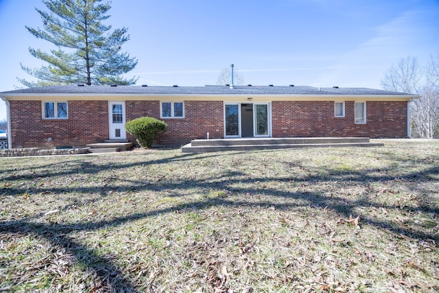 view of front facade featuring a front yard, brick siding, and entry steps